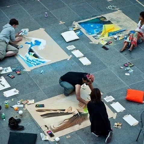 Sher chalk-painting in a public square (from Sher's Instagram)